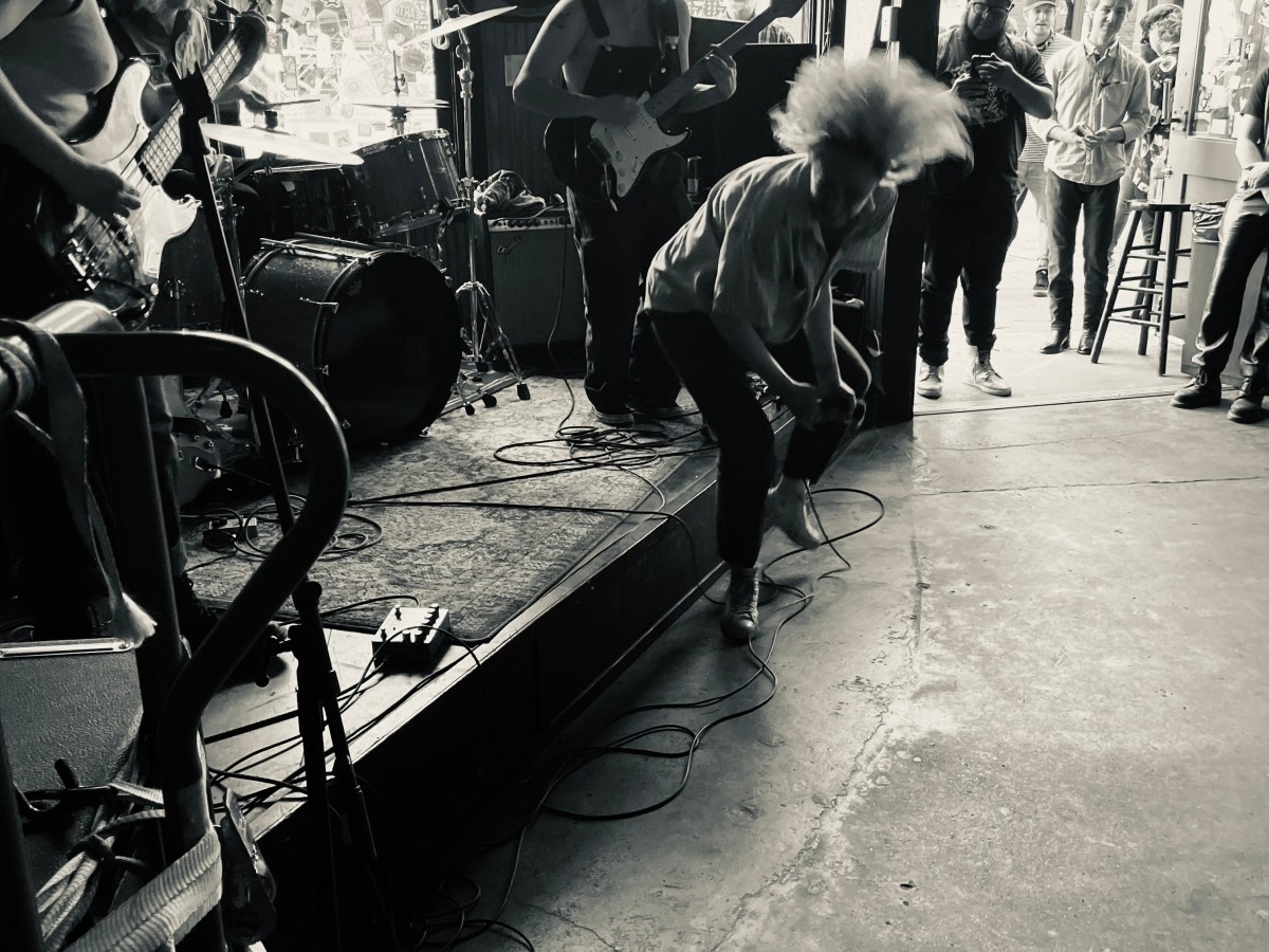 The Bobby Lees performing live on stage with the lead singer captured mid head swing with hair flying.
