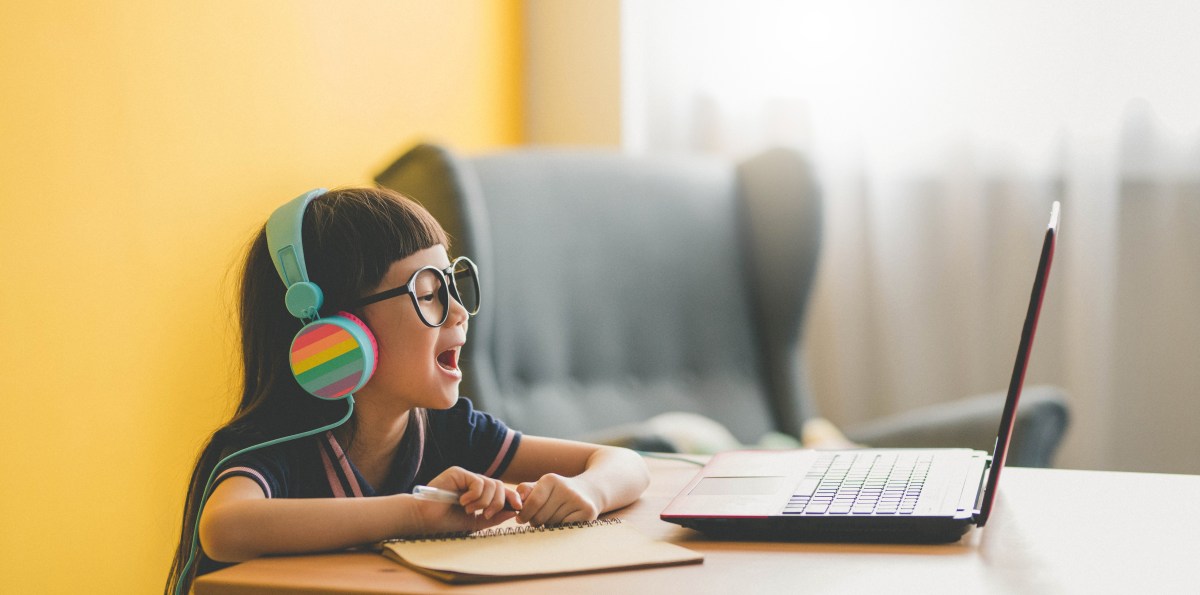 Young Asian Cute girl studying with laptop at home during pandemic stock photo
