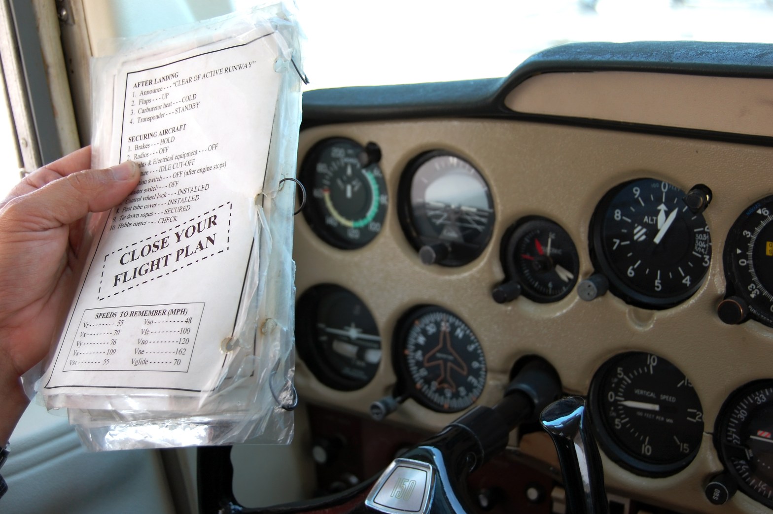 Photo of "Close Your Flight Plan" checklist being followed from inside the cockpit of an airplane.