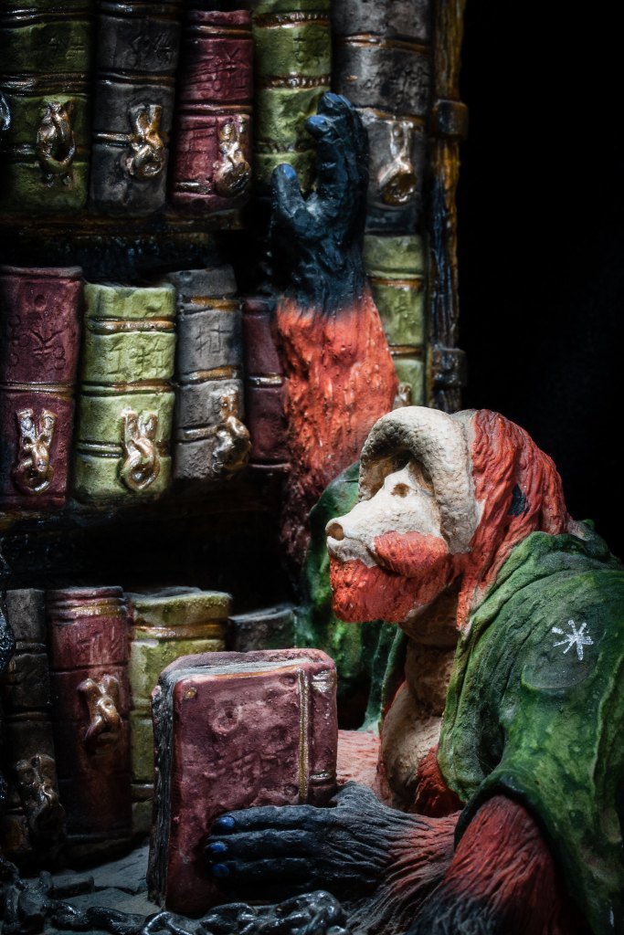 An orangutan climbs library shelves with a book in hand