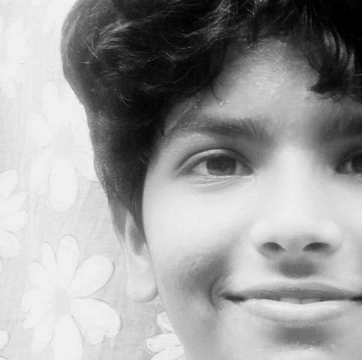 אישה חומת עור עם שיער שחור קצר מחייכת למצלמה