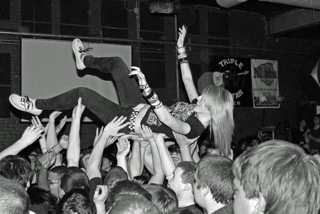 Woman crowdsurfing in a mosh pit