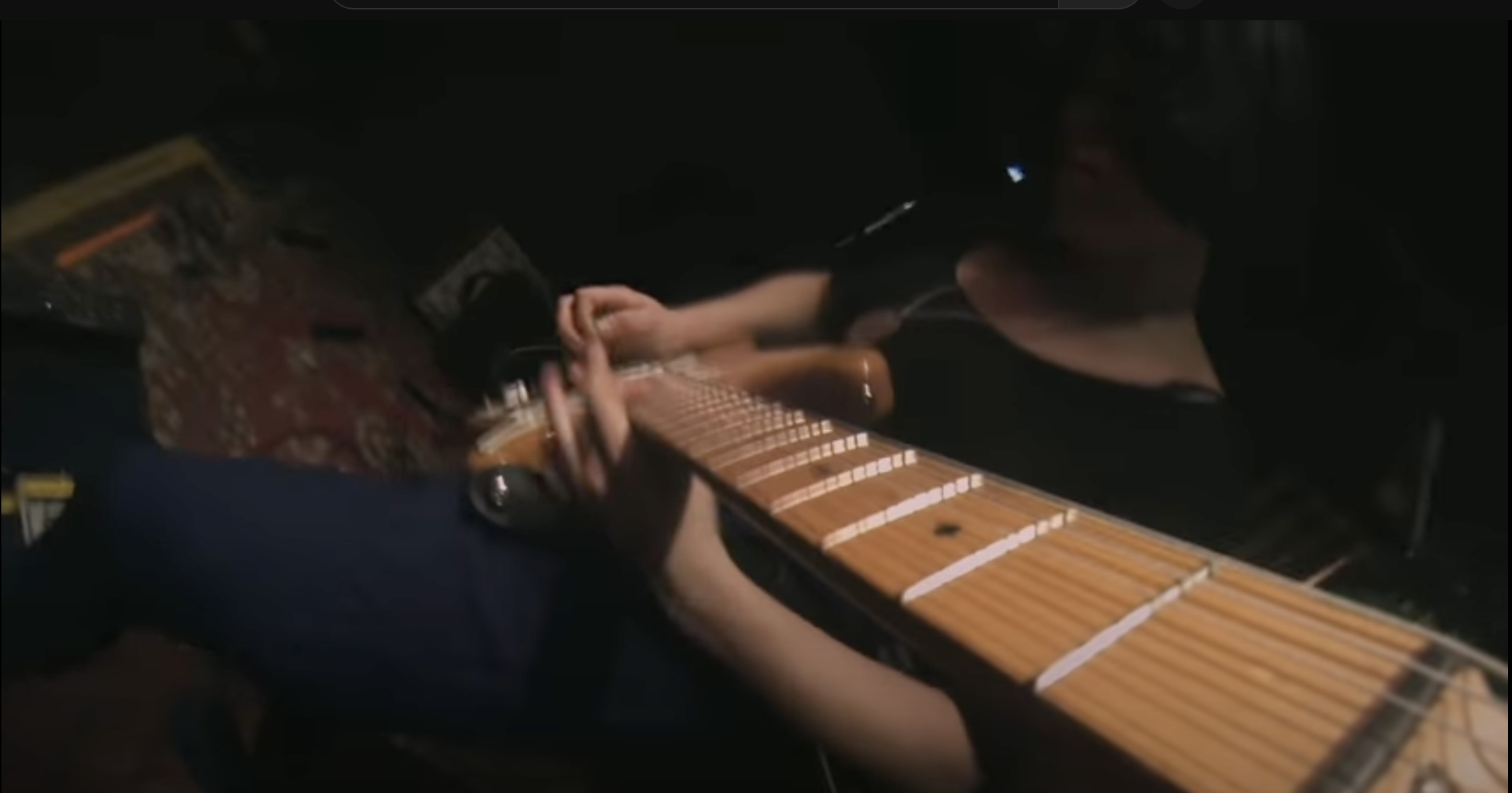 Photo of Marissa Paternoster playing guitar with the camera pointing down the fret board.