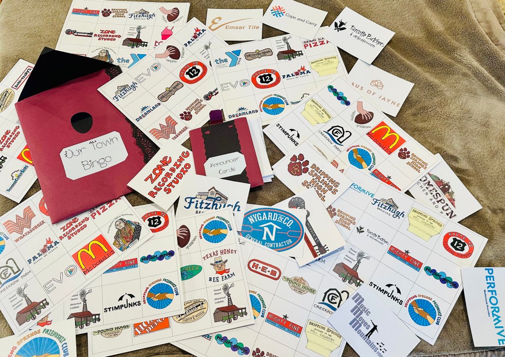Tabletop covered with bingo cards with company logos on them.