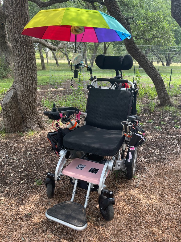 Elektrisk rullstol med regnbågsparaply