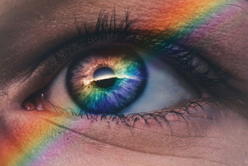 close up photo of rainbow rays across an eye