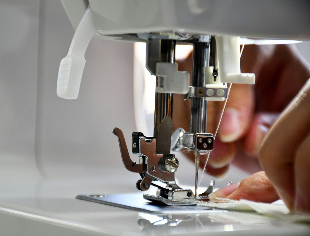 Close up of person using sewing machine