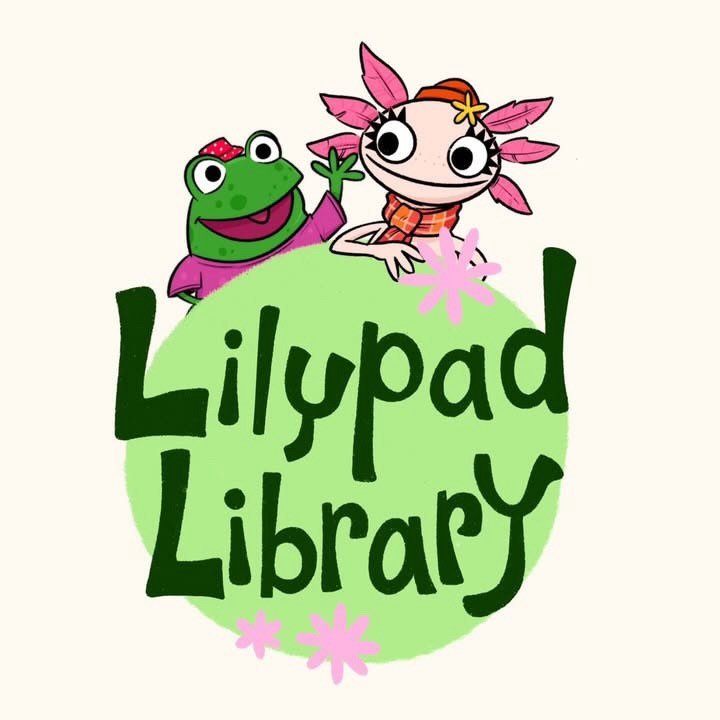 The Lilypad Library logo. A large bright green circle anchors the design, with dark green hand-drawn lettering reading "Lilypad Library" across it in two lines. Perched on top of the circle are two cartoon characters. On the left, a cheerful green frog wearing a magenta top and a small red polka-dot bow, mouth open in a smile, one hand raised in a wave. On the right, a pink axolotl with wide black-and-white eyes, feathery pink external gills, a small yellow flower accessory, and an orange plaid shirt, also waving. Small pink flower accents are scattered around the composition. The background is a warm off-white.