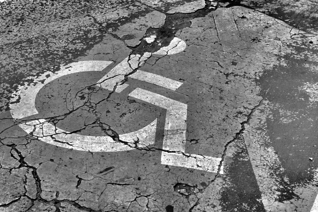 Black and white picture of a dilapidated disabled parking space stock photo